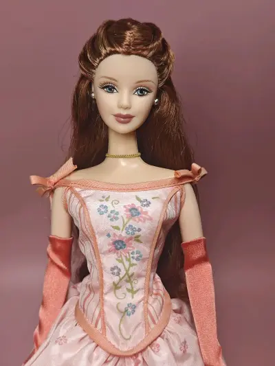 这是2002年美泰推出的**“瑰丽人生系列芭比（Grand Entrance Barbie）”**，是该收藏系列的第二款作品，编号53841，定位为“收藏家限定版”。
 
它的核心设计是浪漫的粉调礼服：上身采用紧身胸衣式剪裁，绣有蓝粉花卉与条纹装饰，裙摆是蓬松的缎面...