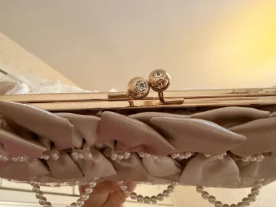 这款浅灰手包堪称温柔系颜值担当：缎面蝴蝶结叠搭珍珠缀饰精致又灵动，网纱波点基底柔雾感拉满，链条腕带适配晚宴、约会等场合，甜而不腻的设计自带浪漫氛围感，是提升造型精致度的小利器。