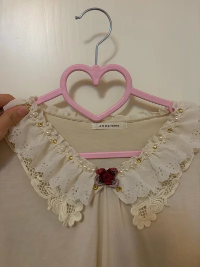 这款axes femme上衣的蕾丝领太戳甜系审美！镂空花边叠珍珠、金饰，暗红玫瑰点缀得温柔又精致，浅米色基底衬得质感柔和，是把浪漫细节焊在领口的少女感单品~