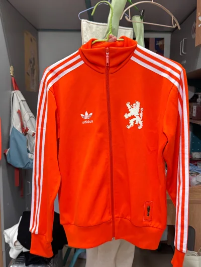 挖煤姬抢到这件Adidas荷兰队世界杯橙色外套，成色新到像刚出厂！激光橙在阳光下艳得炸裂，狮子鬃毛暗纹+立体队徽，复古又未来。平台秒切、EMS十天到手，比现货还香，穿上直接化身克鲁伊夫球场灵魂！