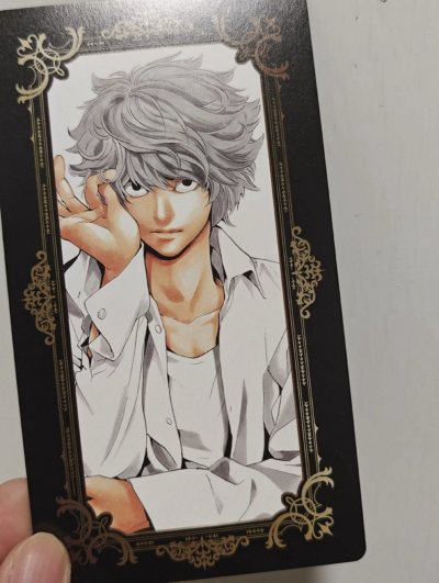 死亡笔记尼亚的特典卡片，选取了他很漂亮的原画，搭配了黑金色的花纹边框，整张卡片都很有质感，虽然有一点点小瑕疵不过也可以理解