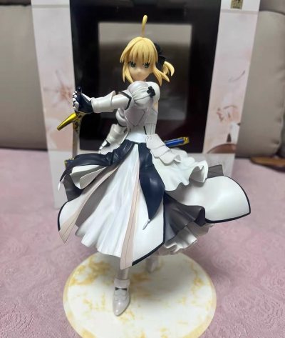 吾王最美的新娘形态，ALTER你是懂的！这圣洁的纯白婚纱礼服，从裙摆的蕾丝到腰间的缎带，细节多到眼花缭乱但无比精致。手持胜利黄金之剑的优雅姿态太戳人了，那种高贵又坚定的“花之圣女”气质拉满。漆面完美，珍珠色的光泽绝了。感谢任意门的神级打包，让这么一件“白色魔王”级易...