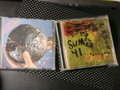 这次收到的CD里，Sum 41的封面涂鸦风直接戳中朋克魂，手绘感的童趣与躁动太有当年的味儿；另一边TERUS SYMPHONIA的《ROCKWORTH EARTH》封面是机械齿轮裹着地球，设计感满到能当艺术品看，拆封时摸到塑封里的实体碟，连曲目表的印刷质感都透着用心...