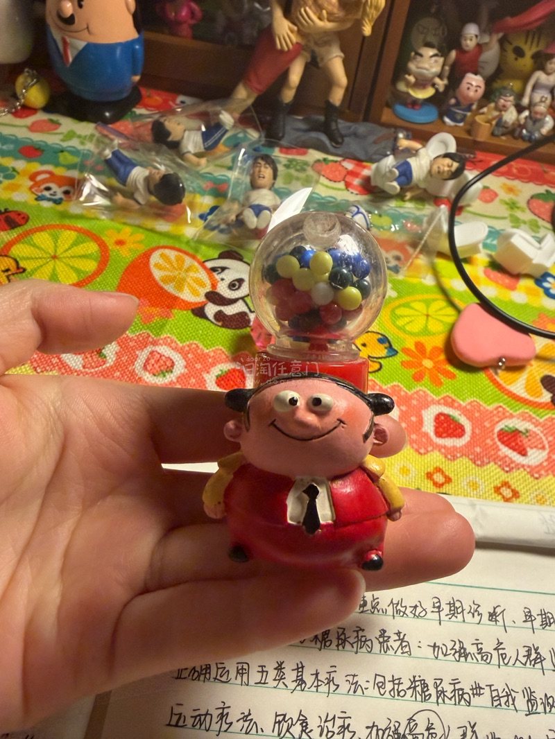这应该是一个游戏机周边的IP，一个胖胖的小子站在一个扭蛋机旁边，超级可爱，是树脂材质的，发货也很快，完美无暇
