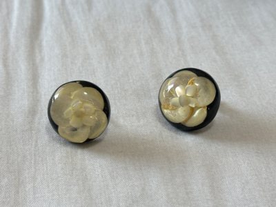 这款山茶花树脂耳夹真的超出预期！拿到手第一感觉就是质感绝了，深色树脂的基底透着温润的光泽，一点都不显廉价，内嵌的山茶花花瓣纹路清晰，金箔的点缀让花朵多了层灵动的珠光感，复古又精致。

上耳特别轻巧，完全没有普通耳夹的坠痛感，隐形夹的设计对无耳洞星人太友好了，戴一整天...