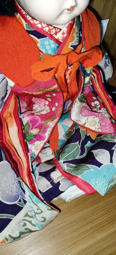 这只日系手工娃娃宛如从和风画卷中走出的稚童，眉眼间藏着温婉的灵韵。脸庞是细腻的瓷质质感，肌肤莹润似玉，眼眸澄澈如秋水，小巧的唇瓣透着淡淡的樱粉，神态天真又恬静，将孩童的纯稚描摹得淋漓尽致。