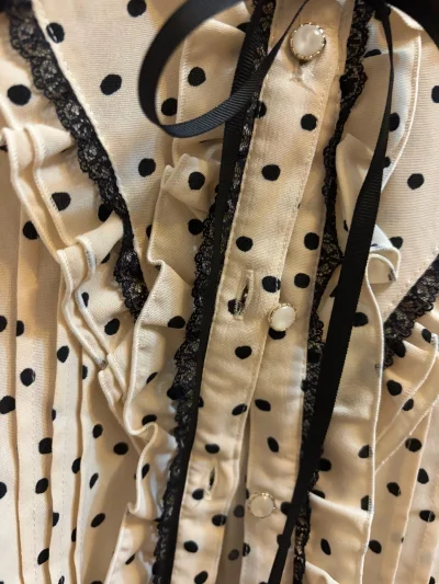 ✨今日份心动单品！这件米白底黑波点衬衫太戳我了，蕾丝包边+蝴蝶结系带又甜又复古，单穿温柔，叠穿也出彩，约会通勤都能hold住～

