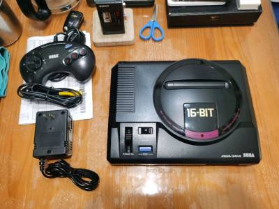 心心念的世嘉MD游戏机漂洋过海来到了我手中，满怀欣喜的小心翼翼打开，又给我了一个大惊喜，几乎全新，外观无瑕疵，新品同样。加上原装大三键手柄和电源，这个寒假可以重温我的童年一会啦。大家猜猜看，会是那个传说中的VA6版本吗？