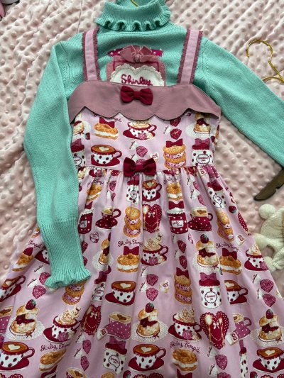 这款Shirley temple粉调满印下午茶主题的吊带连衣裙，是我在挖煤姬上挖到的宝藏好物。它的图案软萌可爱，满印的茶杯、蛋糕与马卡龙图案，完美契合甜系风格。

豆沙粉的花边肩带与胸口的小红蝴蝶结设计精巧，面料柔软亲肤，边缘的毛边包边工艺也很细致。

在挖煤姬平台...这款Shirley temple粉调满印下午茶主题的吊带连衣裙，是我在挖煤姬上挖到的宝藏好物。它的图案软萌可爱，满印的茶杯、蛋糕与马卡龙图案，完美契合甜系风格。 豆沙粉的花边肩带与胸口的小红蝴蝶结设计精巧，面料柔软亲肤，边缘的毛边包边工艺