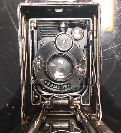 他们都说淘老物件是和时间过招，可我偏觉得——从挖煤姬手中接过的这台皮腔相机，更像是接过一封来自上个世纪的信。

咔嗒一声展开皮腔，时光的折痕便在光影中苏醒。黄铜镜头圈着琥珀色的光，皮腔伸缩时发出叹息般的轻响。取景框里的世界忽然就慢了，慢到能看见尘埃在斜光里跳舞，慢到...