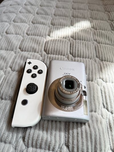 超喜欢，把我的两个心头好一起带回家了！
左边是Switch Joy-Con手柄，成色超新，按键回弹清脆，完全没有漂移问题。价格比国内二手便宜了近一半，用来替换我旧的漂移手柄，简直是性价比天花板。
右边是我的梦中情机——佳能IXY DIGITAL 10。拿到手比图片还...