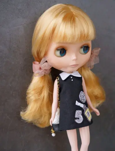 娃娃的金发柔顺有光泽，齐刘海造型俏皮又复古，超大的琥珀色眼珠灵动有神，眼睫毛根根分明，仿佛下一秒就会眨眼。我给她搭配了两套不同风格的穿搭：一套是藏蓝色连衣裙配蕾丝开衫，再加上珍珠十字架项链，优雅又带点神秘；另一套是黑色刺绣连衣裙，搭配双马尾和纱质蝴蝶结。店家的包装非...娃娃的金发柔顺有光泽，齐刘海造型俏皮又复古，超大的琥珀色眼珠灵动有神，眼睫毛根根分明，仿佛下一秒就会眨眼。我给她搭配了两套不同风格的穿搭：一套是藏蓝色连衣裙配蕾丝开衫，再加上珍珠十字架项链，优雅又带点神秘；另一套是黑色刺绣连衣裙，搭配双马