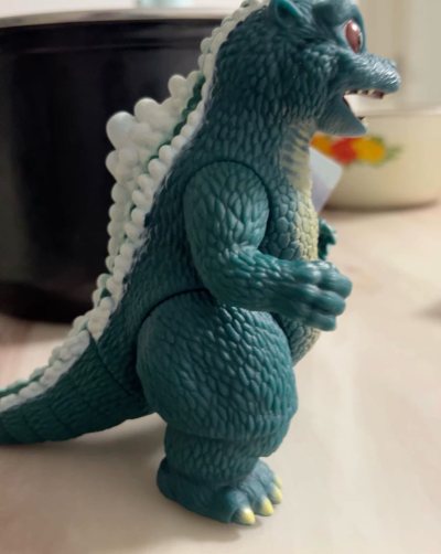 这是万代出品的小哥斯拉（Little Godzilla）软胶手办，出自《哥斯拉VS太空哥斯拉》，圆滚滚的身形搭配呆萌表情，背鳍与腹部纹理细节满满，是兼具收藏与把玩乐趣的可爱怪兽周边。
