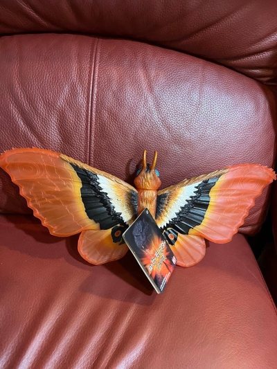 半透橙红的魔斯拉2002剧场限定版，翅脉纹理清晰，金粉点缀其间，如燃烧的蝶翼般轻盈又炽热，尽显守护怪兽的神圣气场。