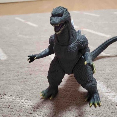 这款2004版哥斯拉软胶还原了《最终战役》的霸气造型，深灰肌理与银白背鳍质感细腻，关节可动性强，摆拍张力拉满，是老粉情怀与收藏价值兼具的佳作。