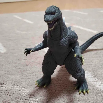 这款2004版哥斯拉软胶还原了《最终战役》的霸气造型，深灰肌理与银白背鳍质感细腻，关节可动性强，摆拍张力拉满，是老粉情怀与收藏价值兼具的佳作。