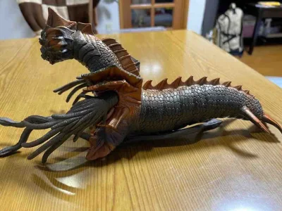 鳞片纹理刻画细腻，头部尖角与额间绿宝石点缀醒目，多根触须状肢体灵活可动，尾鳍与背棘造型凌厉，是极具视觉张力的怪兽藏品。