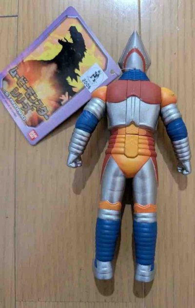 这款2006年电影怪兽系列的喷射杰格软胶，完美还原了经典的机械美学。

整体涂装层次极其丰富，银、橙、蓝、红四色搭配复古且鲜明。头部三角锥造型与黑色护目镜极具辨识度，全身装甲刻线细腻，腰间的蓝色徽章更是点睛之笔，配件卡完整，是极具情怀的经典收藏。
