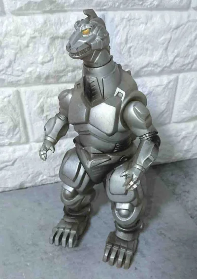 这款机械哥斯拉软胶，通体哑光金属银质感拉满。标志性的黄色机械眼极具威慑力，全身装甲刻线方正硬朗，还原了机械怪兽的冷峻科技感，姿态沉稳霸气，是怪兽系列中极具代表性的经典反派收藏款。