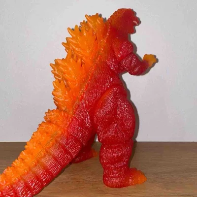 这款红莲哥斯拉软胶，通体红橙渐变的半透质感极具视觉冲击力，完美还原了核能量暴走时的炽热状态。背鳍与身体过渡自然，全身纹理刻画粗犷原始，火焰般的色彩在光线下通透亮眼，尽显王者野性，是收藏中极具特色的经典形态。