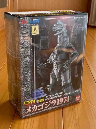 万代超合金GD-56 1974机械哥斯拉，银灰合金质感扎实，全身装甲细节精准，可变形飞行形态，包装完整，是极具情怀与可玩性的经典收藏。