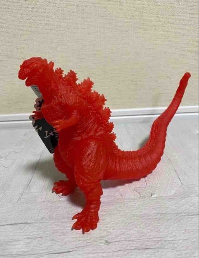 这款真哥斯拉2016限定透明红版软胶，通体半透赤红质感，表皮褶皱与背鳍簇状结构精准还原，限定配色极具视觉冲击力，是收藏中亮眼的特色款。