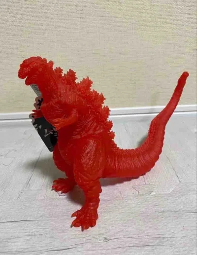 这款真哥斯拉2016限定透明红版软胶，通体半透赤红质感，表皮褶皱与背鳍簇状结构精准还原，限定配色极具视觉冲击力，是收藏中亮眼的特色款。