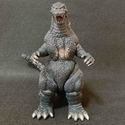 这款经典哥斯拉软胶通体深灰哑光质感，鳞片纹理细密立体，背鳍与爪部银灰点缀，胸肌处做旧提亮，姿态威严，是还原度极高的复古收藏款。
