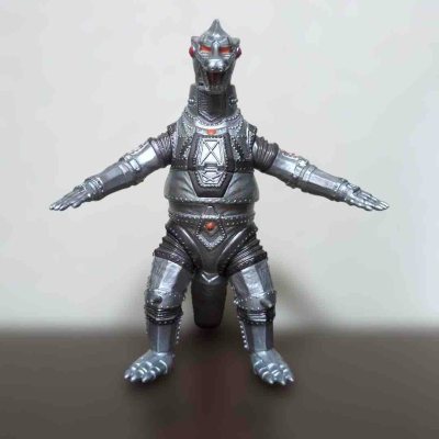 这款机械哥斯拉软胶通体银灰金属质感，铆钉与装甲刻纹还原机械结构，红瞳与胸甲点缀醒目，棱角分明的造型尽显兵器的冷峻与压迫感，是极具硬核风格的经典机甲收藏款。