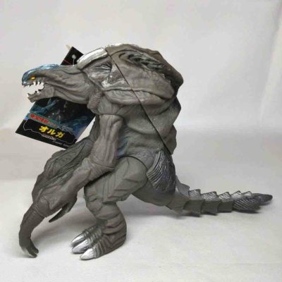 这款奥加（Orga）软胶通体灰褐质感，褶皱与肌肉纹理还原外星生物的怪异形态，蓝银头部与利爪细节锐利，长尾与背棘刻画充满压迫感，是极具异形诡谲感的经典反派收藏款。