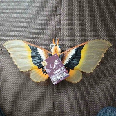 这款摩斯拉软胶翼展宽大，半透翼面纹理细腻，黄黑橙三色渐变层次丰富，眼状斑纹醒目生动，躯体绒毛质感与复眼细节刻画精致，尽显守护女神的华贵与灵动，是极具视觉美感的收藏款。