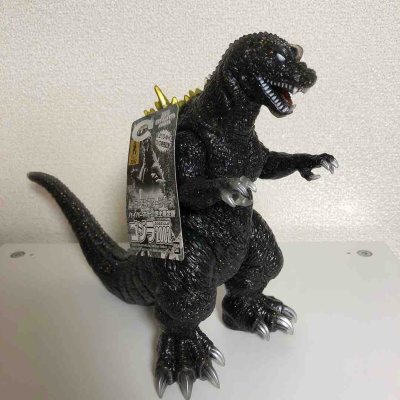 这款2002版哥斯拉手办通体黑金闪粉涂装，质感高级亮眼，背棘渐变金黄，鳞片纹理刻画细腻，爪牙锋利还原度高，分量扎实手感厚重，限定款收藏价值拉满，摆柜气场十足。