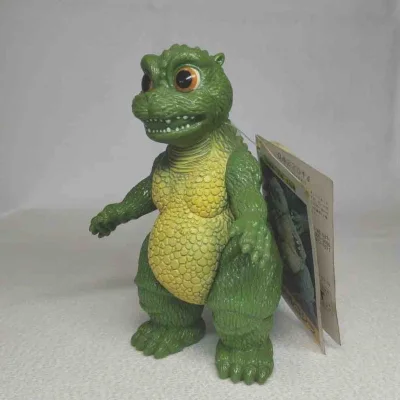 这只小哥斯拉软胶造型憨态可掬，黄绿配色清新可爱，肌理与背鳍细节饱满，大眼萌感十足，是系列里极具亲和力的治愈款。