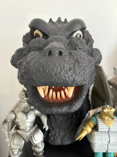 这尊哥斯拉头雕质感拉满，黑胶材质的皮肤颗粒感十足，凹凸纹理还原得很细腻，大眼睛和尖牙神态凶悍，单摆出来就有极强的视觉压迫感，是收藏里的镇柜级单品。