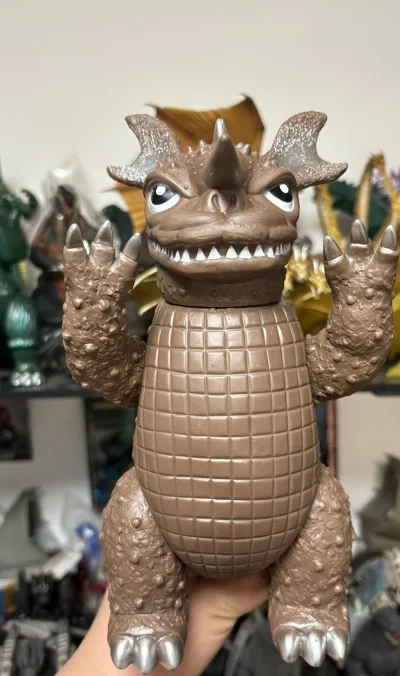 这只迷你巴拉贡手办太讨喜了，棕褐色软胶质感扎实，腹部格纹和肢体颗粒感纹理都刻画得很细腻，单角+大耳的造型憨萌又复古，银漆点缀的爪角细节精致，是收藏里很有怀旧感的萌系怪兽。


