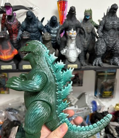 这只绿色哥斯拉软胶手办质感极佳，金属绿漆面流光溢彩，皮肤颗粒感与背棘分层细腻，银爪红瞳的经典配色复古又凶悍，在满柜的哥斯拉收藏里独树一帜，情怀与品相双在线。