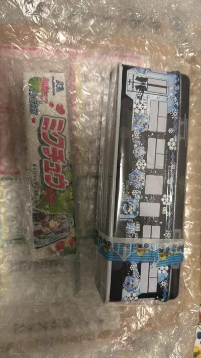 图上的两个分别是2012雪初音零食铁盒，采用电车图案，颇有札幌风情.以及2015生产的森永软糖，印有V家六子的图案