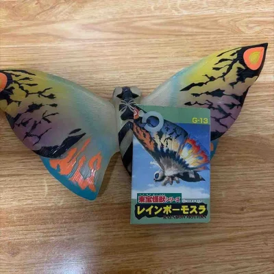 这款剧场限定水晶版彩虹魔斯拉软胶，半透材质自带梦幻光泽，翅膀渐变色彩层次丰富，带吊牌品相完好，是魔斯拉系列收藏的稀有好物。