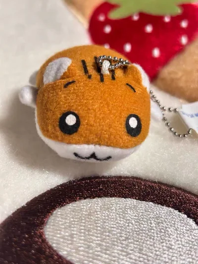 终于入手了仓鼠管家毛绒挂件！软乎乎的毛绒材质摸起来超舒服，橙白配色和呆萌表情都完美还原了角色，金属珠链挂在包上既精致又吸睛。作为经典日系IP，它自带的治愈感太戳人了，每次看到都能缓解疲惫，性价比和颜值都在线，强烈推荐给喜欢可爱小物的朋友～
