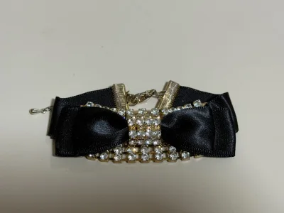 这款精致黑蝴蝶结手链，满镶闪耀水钻，金色金属衔接。缎面蝴蝶结衬得钻饰更璀璨，链条设计灵动，温柔又显贵气。