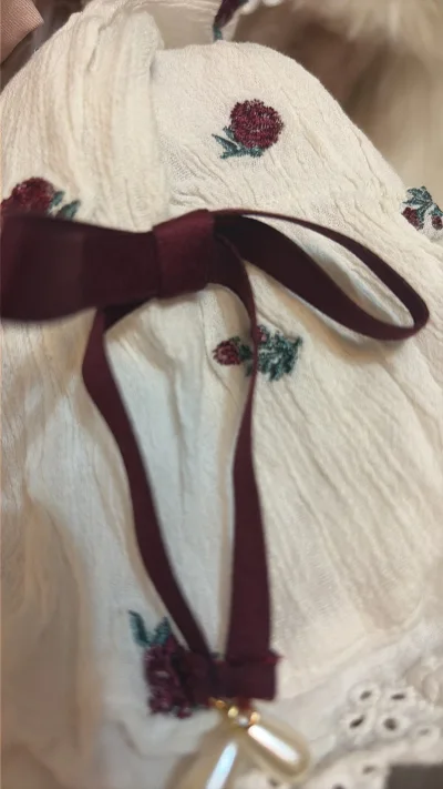 挖到春日宝藏上衣！米白底绣满红玫瑰超温柔，一字肩露锁骨超显气质✨ 面料软糯透气，袖口蝴蝶结细节满满，藏肉又显瘦。搭牛仔或半裙都绝，性价比超高，闭眼冲不亏！