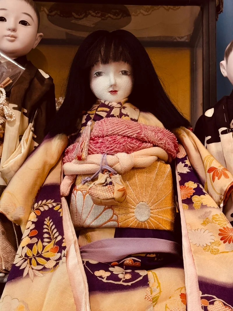 最让人心动的，是那身极致华美的和服。正绢面料泛着柔和光泽，友禅染的纹样雅致细腻，从樱花、菊纹到古典几何，一针一线皆为手工缝制￼￼￼。腰带繁复打结，衣袂垂坠自然，每一处剪裁、每一个细节，都还原着日式传统服饰的精致与考究。为它轻轻整理衣摆时，仿佛在呵护一件稀世艺术品，那...