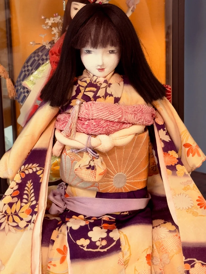 最让人心动的，是那身极致华美的和服。正绢面料泛着柔和光泽，友禅染的纹样雅致细腻，从樱花、菊纹到古典几何，一针一线皆为手工缝制￼￼￼。腰带繁复打结，衣袂垂坠自然，每一处剪裁、每一个细节，都还原着日式传统服饰的精致与考究。为它轻轻整理衣摆时，仿佛在呵护一件稀世艺术品，那...