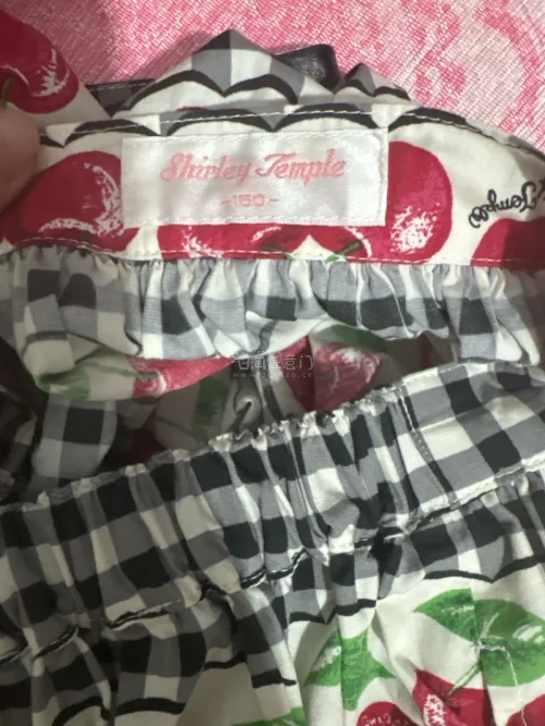 这条半身裙采用松紧腰设计，穿脱方便。黑白格纹搭配饱满鲜红的樱桃印花，层层拼接的蛋糕版型，甜美复古，面料轻薄，充满少女田园感。黑白格子底色和樱桃图案交错排列，波浪花边分割色块，裙摆宽松蓬松，整体元气满满，很适合日常休闲穿搭。