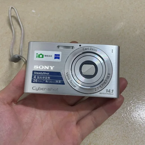 最近入手这台日版索尼DSC-W320，真的有种回到千禧年的感觉。机身是经典的银色卡片机，滑盖开机很顺手，拿在手里小小的一只，出门揣包也不占地方。它的拍照氛围很柔和，尤其适合拍日常、街景、咖啡店和复古穿搭，画面带一点旧数码相机的颗粒感，不是现在手机那种过度锐化的质感。...