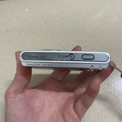 最近入手这台日版索尼DSC-W320，真的有种回到千禧年的感觉。机身是经典的银色卡片机，滑盖开机很顺手，拿在手里小小的一只，出门揣包也不占地方。它的拍照氛围很柔和，尤其适合拍日常、街景、咖啡店和复古穿搭，画面带一点旧数码相机的颗粒感，不是现在手机那种过度锐化的质感。...
