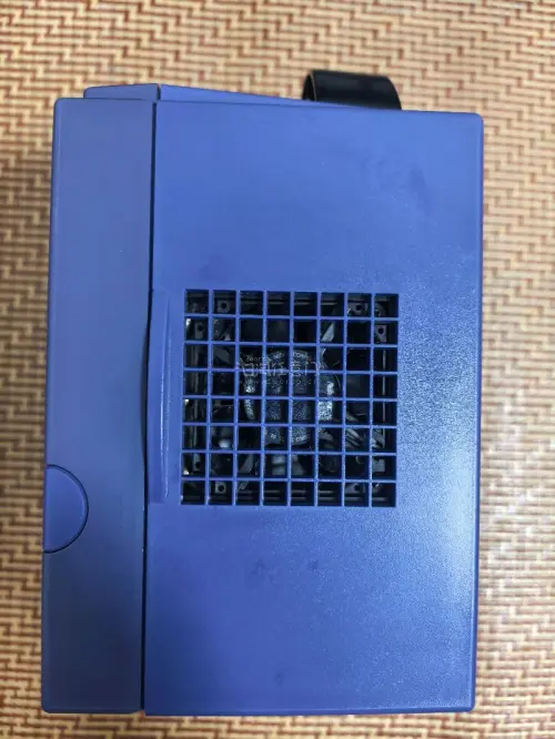 这是一台任天堂GameCube（NGC）家用游戏机，经典的紫罗兰紫配色。
机身上方是光盘仓，正面配备四个手柄接口，下方有SLOT‑A、SLOT‑B两个记忆卡插槽，右下角印有ATI的标识，代表该机的图形芯片由ATI提供。
 这台是任天堂2001年推出的第六代家用主机，...